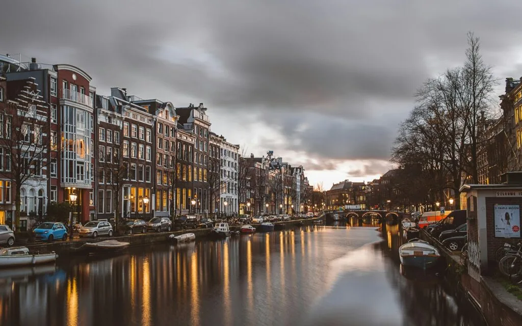Amsterdam canal lined with historic buildings at dusk, for Dutch businesses meeting WEEE compliance