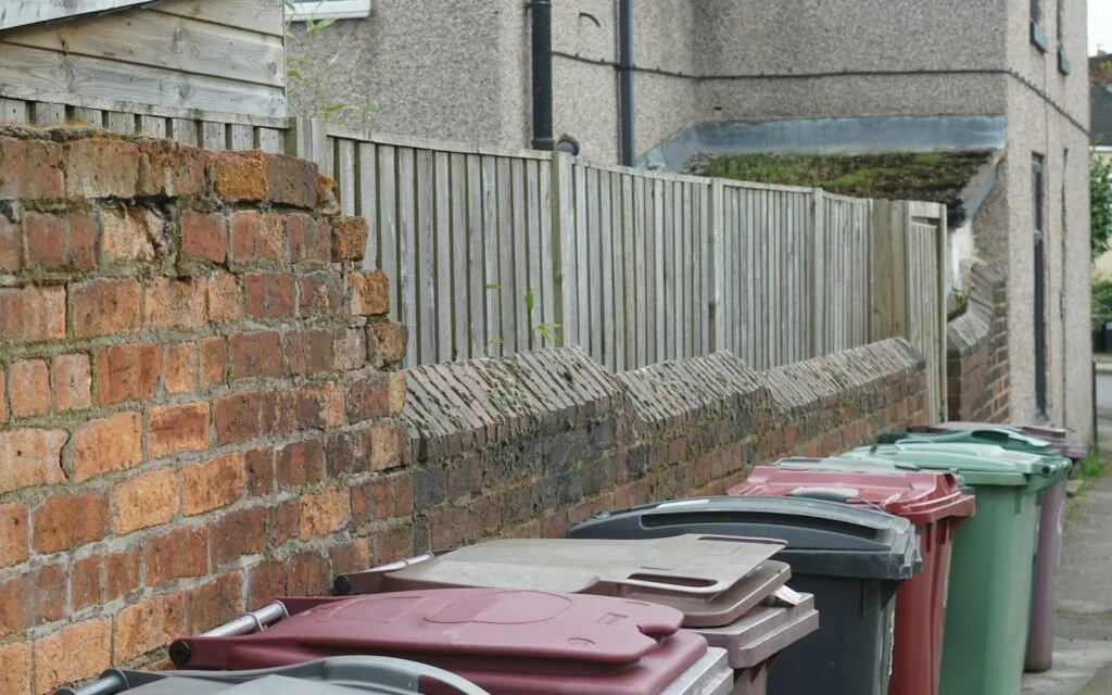 Row of colourful wheelie bins, where electronics and batteries should never be thrown